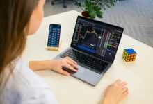 a woman sitting at a table using a laptop computer