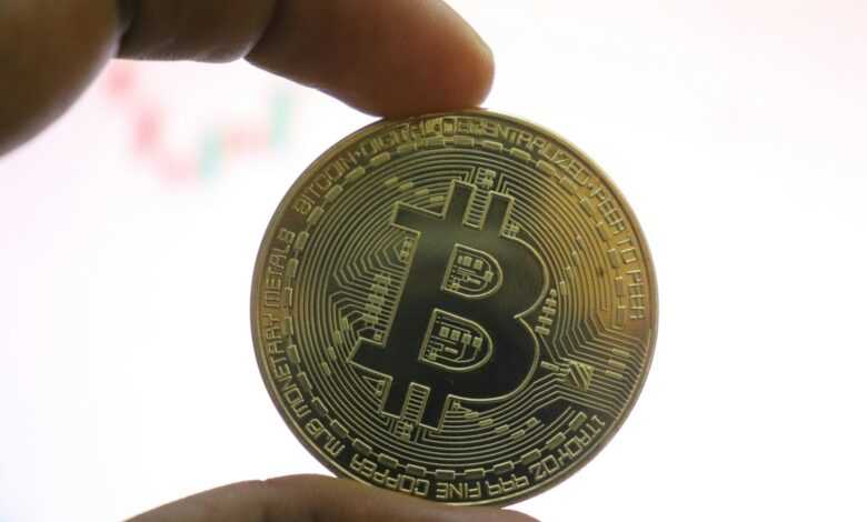 a person holding a bit coin in their hand