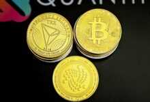 three gold bitcoins sitting on top of a black table