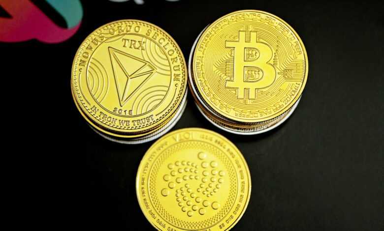 three gold bitcoins sitting on top of a black table